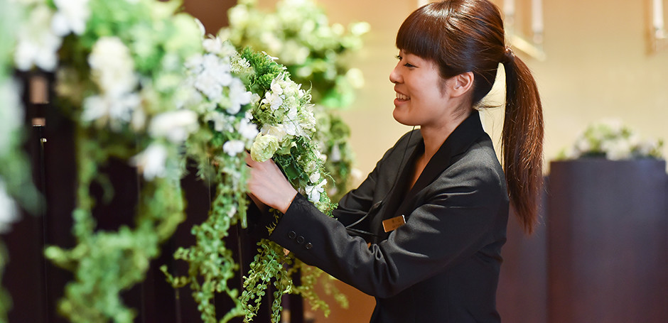 式場に花を飾るプランナー